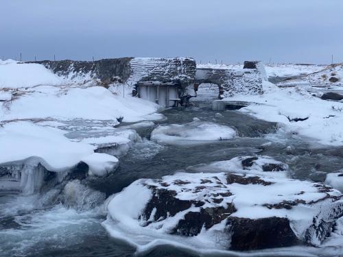 a river covered in snow and ice at Álftártunga Farm Guesthouse in Borgarnes