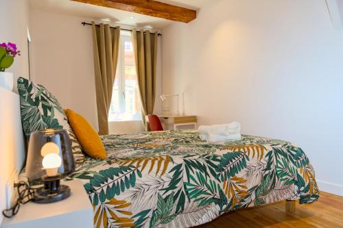 a bedroom with a bed with a colorful comforter at Le Saint Rome - Toulouse Hypercentre in Toulouse