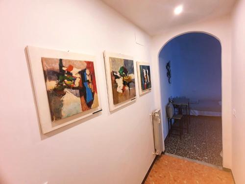 a hallway with three paintings on a wall at Ariel in La Spezia