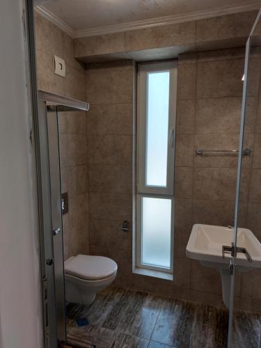 a bathroom with a toilet and a sink and a window at SAPPHIRE in Sozopol