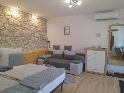 a bedroom with a bed and a stone wall at Kaland apartman II. in Sátoraljaújhely