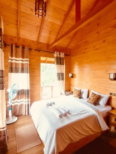 a bedroom with a large bed in a wooden room at Green Nature Paradise Ella in Ella
