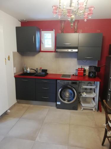 une cuisine avec une cuisinière et une machine à laver dans l'établissement Appartement de plain pied dans la verdure, à Yerres