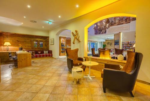 a lobby of a store with chairs and a table at Berghotel Hammersbach in Grainau