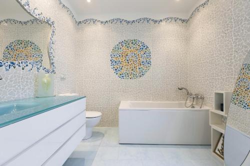 a bathroom with a white tub and a toilet at Haizea by Smiling Rentals in Hondarribia