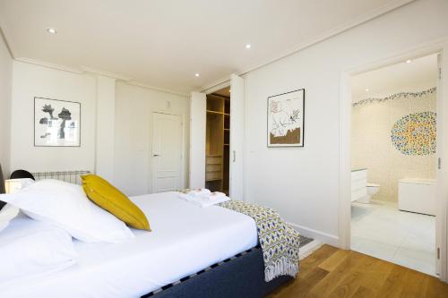 a bedroom with a bed with a yellow pillow on it at Haizea by Smiling Rentals in Hondarribia