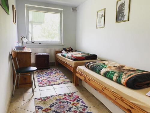 a room with two beds and a table and a window at Lansada in Zabór