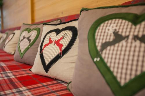 a group of pillows with hearts on a bed at Berghotel Hammersbach in Grainau