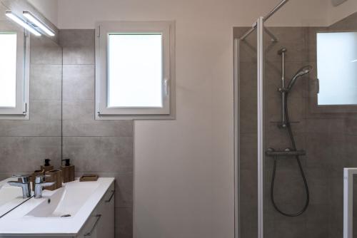 ein Bad mit einer Dusche und einem Waschbecken in der Unterkunft Pietra in Calvi