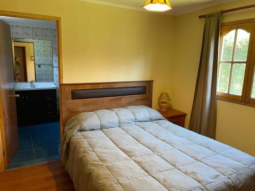 Cajon del MaipoにあるLinda casa en El Manzano con hermosa vista!!!のベッドルーム(大型ベッド1台付)、バスルームが備わります。