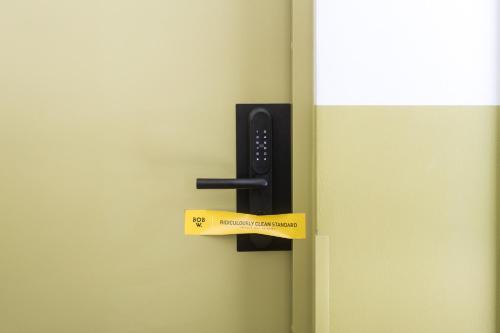 a black door handle with a yellow tag on it at Bob W Kluuvi in Helsinki