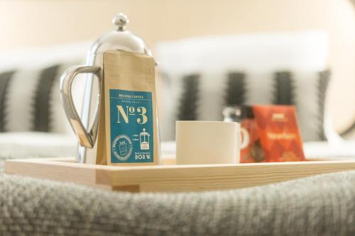 a coffee pot and a cup on a wooden tray at Bob W Kluuvi in Helsinki