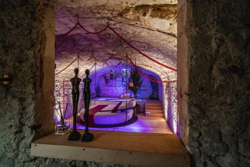 a room with a bed and a purple light at Airb&Sexy in Béziers