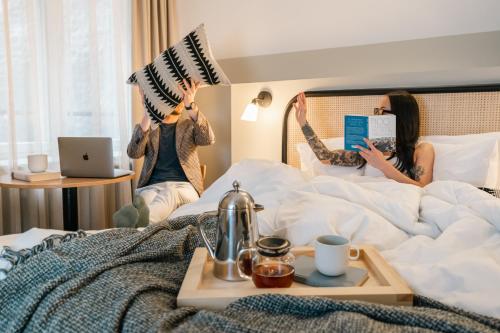 twee vrouwen die op een bed springen met hun handen in de lucht bij Bob W Kluuvi in Helsinki