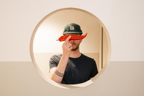 a man holding a hot dog in front of a mirror at Bob W Kluuvi in Helsinki