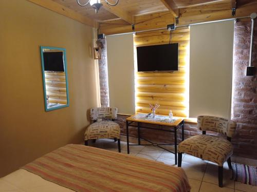 a bedroom with a bed and a table and a tv at Quedate Apart Hotel in Correa