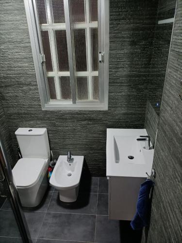 ein Bad mit einem WC, einem Waschbecken und einem Fenster in der Unterkunft Bergantin 8 in Torrevieja