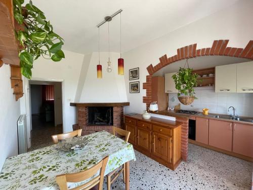 a kitchen with a table and a fireplace at Casa Delle Mura in Montemerano