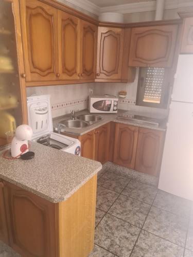 a kitchen with wooden cabinets and a white stove top oven at Apartamento Mari in Agua Amarga