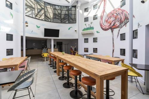 a room with tables and chairs and a large ceiling at Victoria Garden Bordeaux Centre in Bordeaux