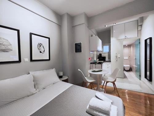 a bedroom with a bed and a table and a kitchen at Zea Apartments in Piraeus