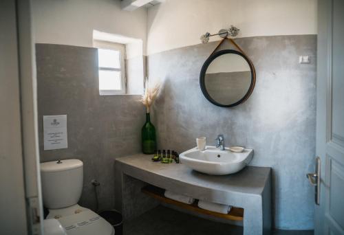 La salle de bains est pourvue d'un lavabo, de toilettes et d'un miroir. dans l'établissement Soros Beach Antiparos, à Agios Georgios