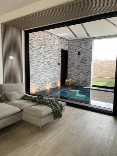 a living room with a couch and a swimming pool at AB Villa in Ajman 