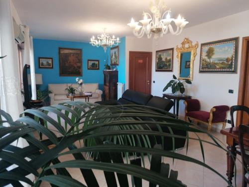 un soggiorno con pareti blu e lampadario a braccio di B&BYanet's Beautiful House a Civitavecchia