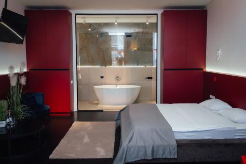 a bedroom with a bathroom with a tub and a bed at Arkadia Beach Hotel in Odesa