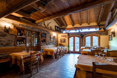 Agriturismo Belotti في تيمو: مطعم فيه طاولات وكراسي في الغرفة