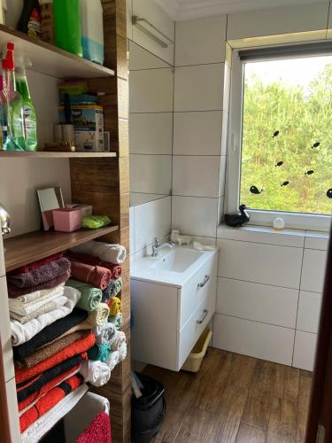 a small bathroom with a sink and a window at Kaszuby- Domek całoroczny nad Jeziorem Gowidlińskim in Sulęczyno