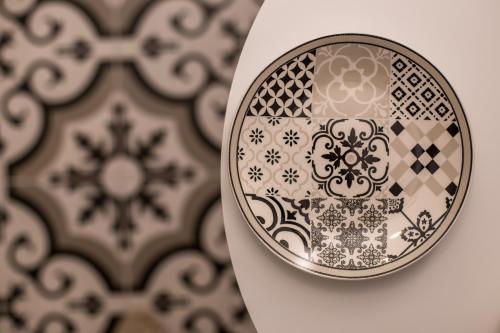 a plate with a pattern on it next to a wall at Marini Seaside in Faliraki
