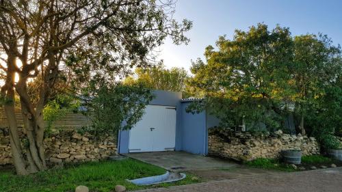 a garage with a white door and a stone wall at Buchu & Num-num in Stanford