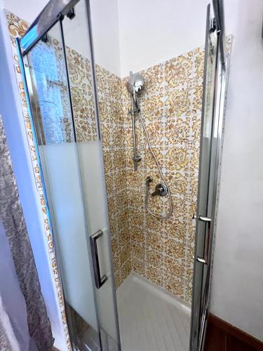 a shower with a glass door in a bathroom at Alla Scalinata del Teatro Rossetti confort suites parcheggio in Trieste