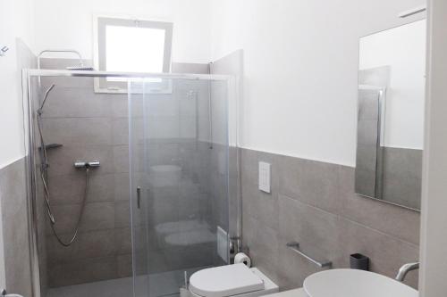a bathroom with a shower with a toilet and a sink at Villetta Emma in Torre Lapillo