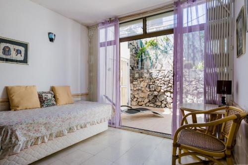 ein Schlafzimmer mit einem Bett und einer Glasschiebetür in der Unterkunft Sea Front Costa Adeje Bungalow in Adeje