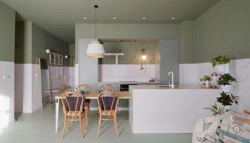 una cocina con encimera blanca y sillas. en Apartamento diseño Galiana 6 Avilés Asturias, en Avilés