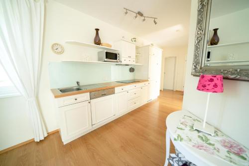 a kitchen with white cabinets and a sink at Villa Hubertus Enzian in Kirchbach