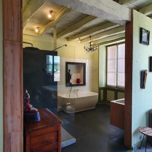 une grande salle de bain avec une baignoire et un lavabo dans l'établissement Maison Fossemagne, à Melle