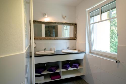 a bathroom with two sinks and a window at Villa Hubertus Enzian in Kirchbach