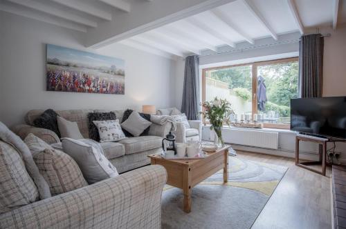a living room with a couch and a tv at Wern Y Glais - 2 Bedroom Cottage - Glais in Swansea