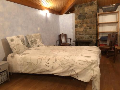 une chambre avec un lit avec une couette blanche dans l'établissement Maison Coquelicot, à Chanéac