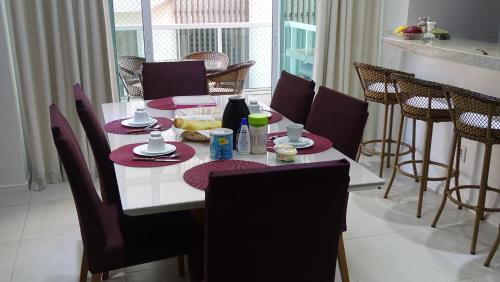 tavolo da pranzo con sedie e tavolo con cibo di Belíssimo Apto à Beira Mar ad Arraial do Cabo