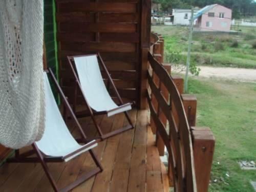 two chairs sitting on the porch of a house at Complejo La Pausa in Punta Del Diablo