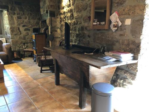 - un bureau en bois dans le salon avec une table dans l'établissement Maison Coquelicot, à Chanéac