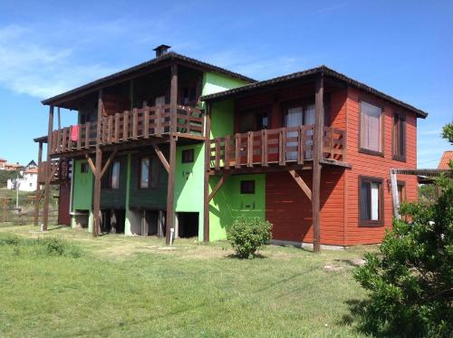 a wooden house with balconies on the side of it at Complejo La Pausa in Punta Del Diablo