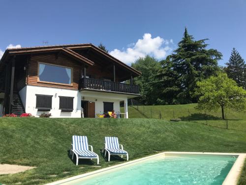 two chairs and a house with a swimming pool at Villa Tirolese in Due Cossani