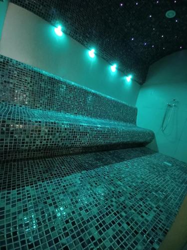 a bathroom with a tub with blue lights on it at Hotel Carmen in Predeal