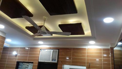 a ceiling fan in a bathroom with brown tile at Posh, Nice Foreigner Area Lajpat Ngar Luxury Room in New Delhi