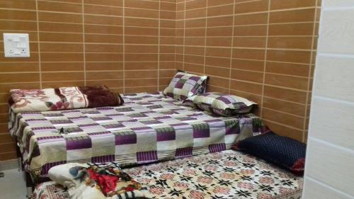 a room with two beds in a tiled wall at Posh, Nice Foreigner Area Lajpat Ngar Luxury Room in New Delhi